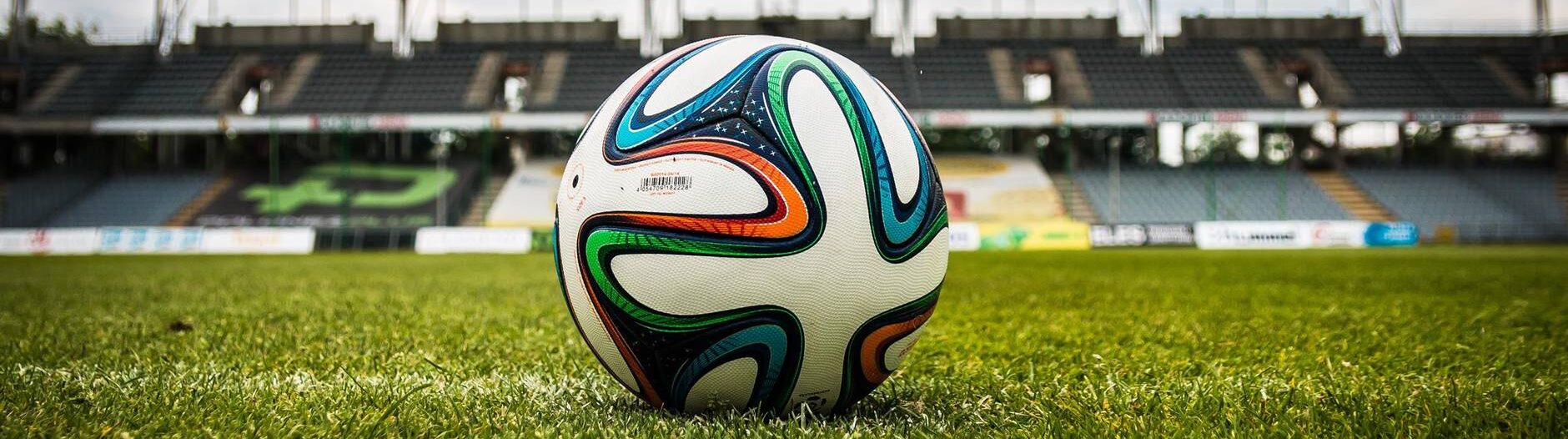 multicolored soccer ball on green field