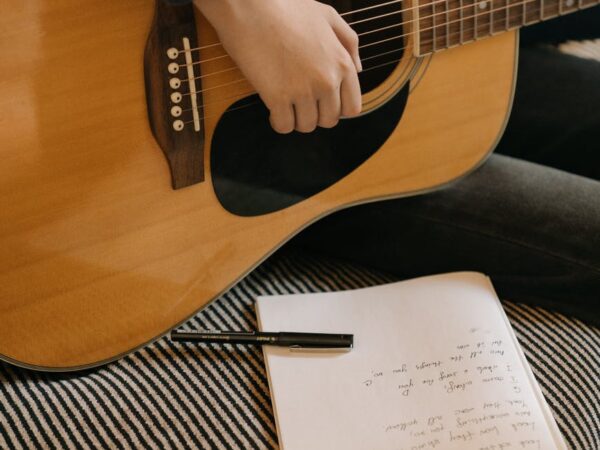 brown acoustic guitar on brown and black stripe sofa