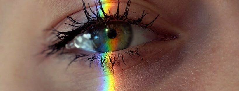 anonymous woman with rainbow light on face