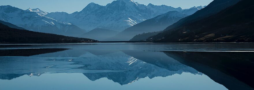 calm body of lake between mountains